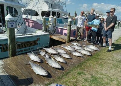 A group of people pose with fish after a fishing charter trip in Outer Banks, NC.